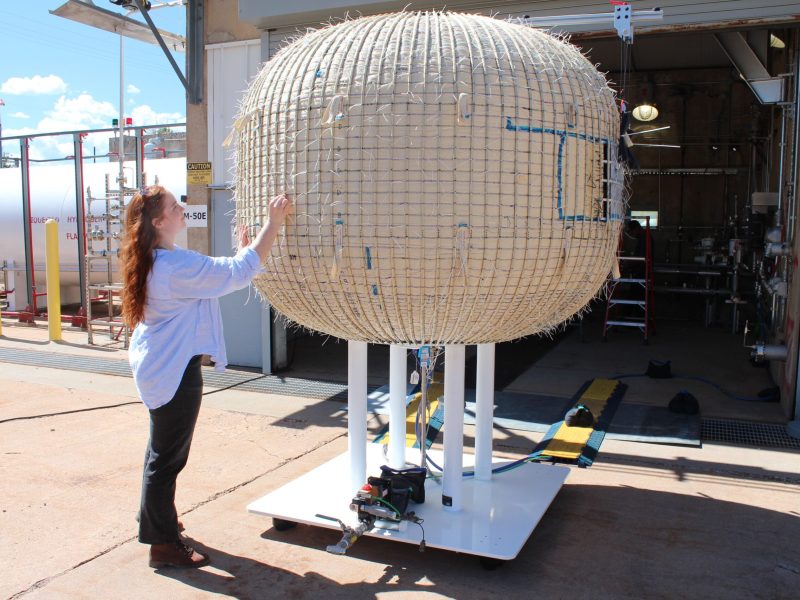 Rowan Palmer, a systems engineer within the Lockheed Martin Space softgoods and habitation team, inspects an inflatable airlock test unit. Credit: Barbara David