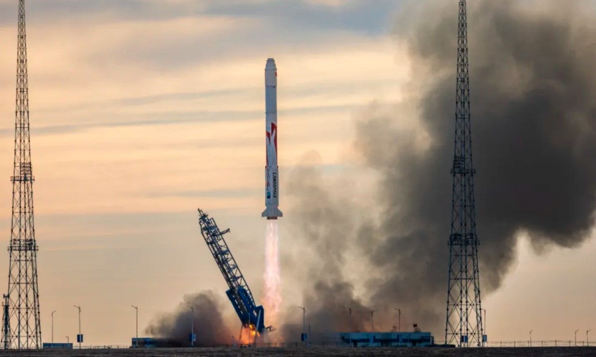The white and red Zhuque-2E Y1 rocket launch by Landspace on November 27, 2024, against a morning sky, with an exhaust plume and smoke billowing as the rocket ascends.